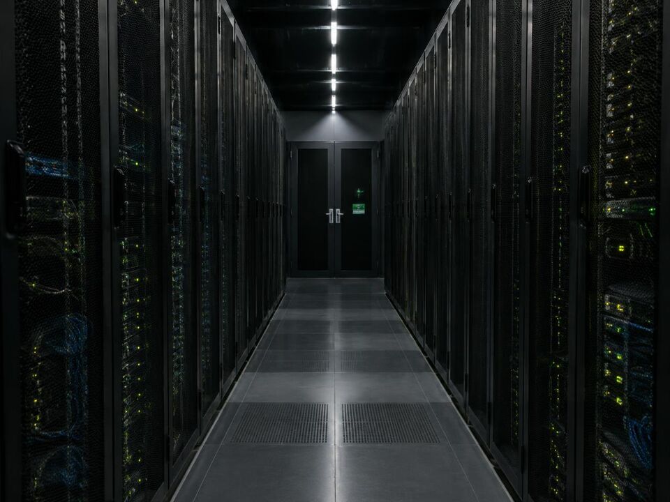 Corridor of server racks with small green status lights